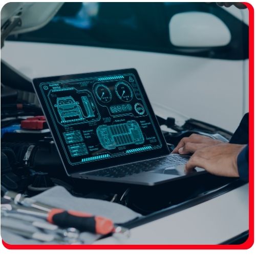 Mechanic using diagnostic software on laptop to assess vehicle performance under the hood.