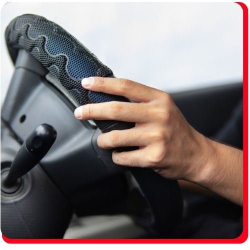 Driver's hand on steering wheel showing symptoms of CV axle issues.