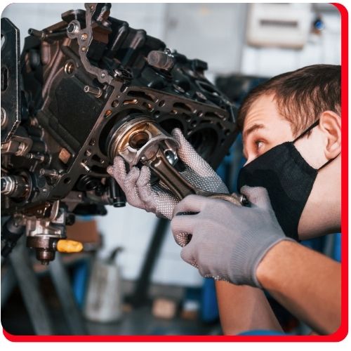 Mechanic closely inspecting internal components of a vehicle transmission during an overhaul.