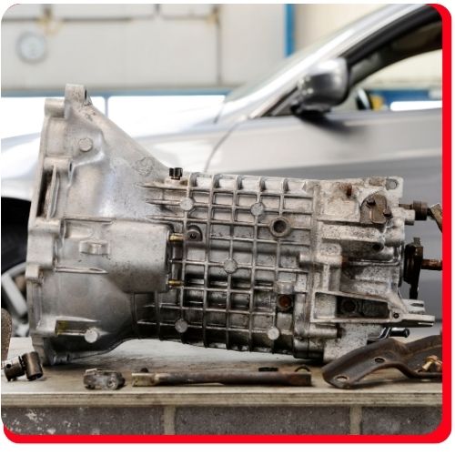 Close-up of a used transmission unit removed for overhaul at an auto repair shop.